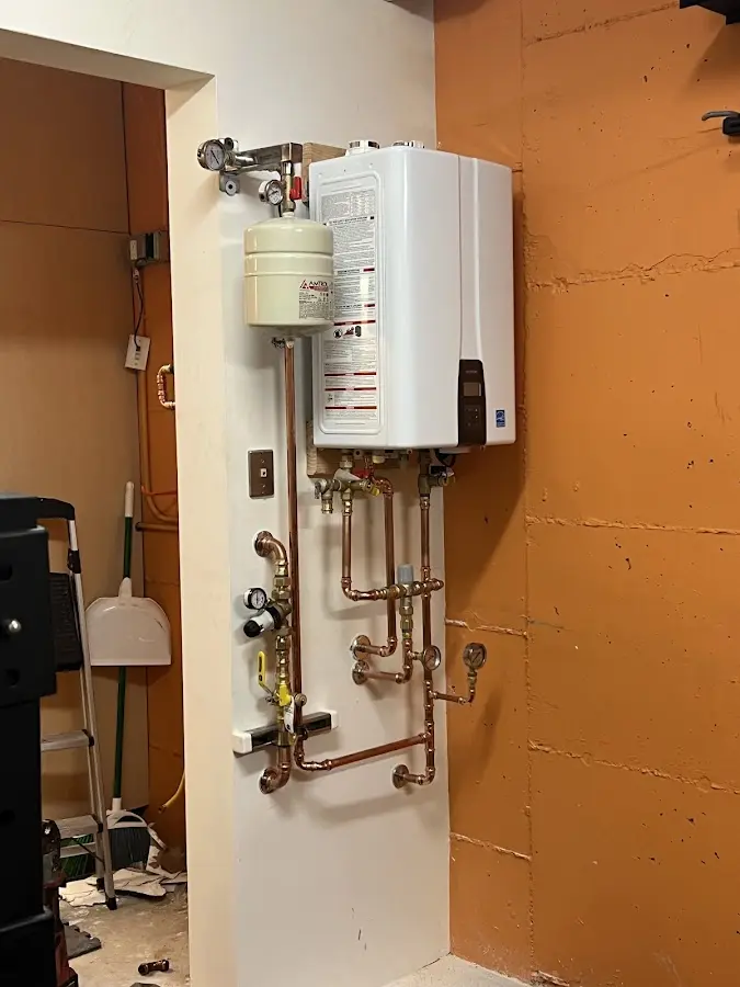 Plumbing technician inspecting water heater connections in Hampstead